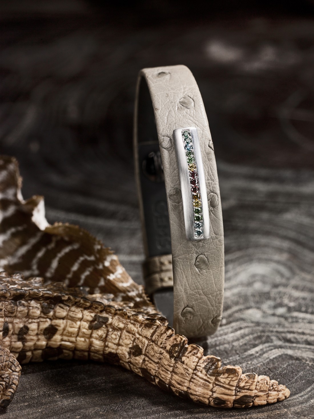 Bijou accessoire homme : Bracelet en autruche sable, barrette en or gris satiné brossé, sans émail, diamants multicolores.
